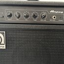 Černý basový kombozesilovač s logem Ampeg a označením BA-108. Ovládací panel obsahuje pět otočných potenciometrů s popisky Volume, Bass, Mid, Treble…
