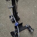 Černý basový pedál s kovovými prvky a pružinou. Na bočním rámu je svisle napsán bílý text "HARDWARE-2005". Zařízení je umístěno na betonovém povrchu.