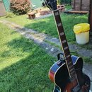 Elektrická polodublová kytara v hnědém sunburst provedení s černým lemováním. Na hlavě je bílý nápis Ibanez a logo s písmenem S. Hmatník má světlejší…