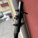 Fotografie zachycuje hlavu černé elektrické kytary s ladicími kolíky. Na horní části hlavy je vidět bílý nápis „stone“. Povrch nástroje vykazuje drob…