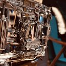 Detailní pohled na chromovaný snare drum (malý buben). Na mechanismu napínání je viditelný nápis "Pearl". Povrch chromovaných částí je lesklý s vidit…