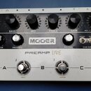 Bílý kytarový předzesilovač značky MOOER s označením PREAMP LIVE. Horní panel obsahuje šest černých otočných ovladačů s popisky VOL, BASS, MID, TREBL…