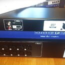 Tři rackové zařízení v černých šasi umístěná nad sebou. Horní přístroj má nápisy WiFi, MEDIA, AFS2 a AUX OUTPUTS s čtyřmi konektory. Prostřední modré…