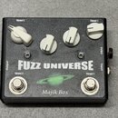 Černý efekt pedál s nápisy FUZZ UNIVERSE a Majik Box. Na horní straně jsou čtyři bílé ovládací knoflíky s popisky Thrust 2 a Thrust 1. V dolní části…