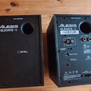 Dva černé studiové monitory z pohledu zadní strany. Na obou je bílý nápis ALESIS ELEVATE 4 a označení LEFT SPEAKER u levého a RIGHT SPEAKER u pravého…