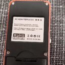 Zadní strana efekt pedálu s červeným rámem a černým plastovým krytem. Uprostřed je bílá nálepka s nápisy AC ADAPTER DC9V, MADE IN CHINA, RoHS a CE, d…