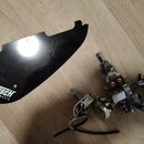Černý plastový plech s bílým nápisem GRETSCH ELECTROMATIC. Vedle něj je umístěna elektronika s potenciometry, přepínačem a připojenými vodiči. Povrch…