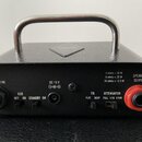 Zadní strana černého kytarového zesilovače s kovovou rukojetí. Jsou zde viditelné nápisy PHONES / LINE, ECO OFF ON STANDBY ON, DC 19 V, EQ FLAT DEEP,…