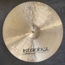 Kruhová mosazná činely s viditelným kování povrchu. Na spodní části je černý nápis istanbuL®, pod ním kurzívou Mehmet a text Handmade Cymbals from Tu…