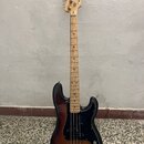 Elektrická basová kytara s trupem v sunburst provedení a černým pickguardem. Na hlavě hmatníku je viditelný nápis Squier. Krk a hmatník jsou vyrobeny…