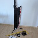 Černý keytar s bílým povrchem na pravém boku, který je zdoben červenými skvrnami připomínajícími krev. Na hmatníku je svisle napsáno AX-Edge a v doln…