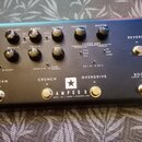Černý kytarový zesilovač s nápisem AMPED 3 a doplňkem DEPT. 10 | 100W 3 CHANNEL AMP. Přední panel obsahuje dvě řady ovladačů a přepínače pro funkce C…