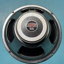 Fotografie znázorňuje reproduktor s černým rámem a šedým středovým krytem. Na středovém krytu je logo CELESTION a nápis 80 SEVENTY. Na horním okraji…