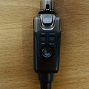 Černý a stříbrný elektronický přístroj s ovládacími prvky. Na přední straně jsou tlačítka s nápisy AUX, POWER, LINE a MUTE a pod nimi kulatý ovladač.…