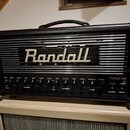 Černý kytarový kombozesilovač s výrazným bílým nápisem Randall na předním mřížkovém panelu. Spodní ovládací panel obsahuje řadu potenciometrů a přepí…