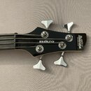 Fotografie zachycuje hlavu černé basové kytary s chromovanými ladičkami. Na hlavě jsou bílé nápisy „Ibanez“, „SOUNDGEAR“ a „mikro“. Povrch je glossy,…