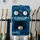 Modrý efekt pedál s nápisy COMP/LIMIT, GAIN a MODE (TUBESIM, MB, NORMAL). Uprostřed je velký bílý nápis MULTICOMP a text True Dual Band Compressor. V…