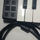 Kompaktní MIDI klaviatura s bílými a černými klávesami. Na černém ovládacím panelu je nápis AKAI professional a model LPK25 LAPTOP PERFORMANCE KEYBOA…