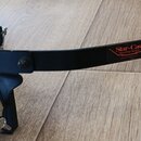 Černý kovový držák na buben s chromovaným úchopem. Na rameni je červený štítek s nápisem Star-Cast Mounting System a menším textem MADE IN TAIWAN R.O…