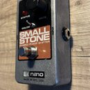Stříbrný efekt pedál s černým ovládacím panelem a hnědým štítkem. Na štítku je bílý nápis SMALL STONE a pod ním EH4800 PHASE SHIFTER. Na spodní části…