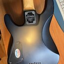 Zadní strana elektrické kytary s matně černým povrchem a světle hnědým krkem. Nadesníkovémdesce je nápis Schecter DIAMOND SERIES 1840 VALENCIA ST. BU…