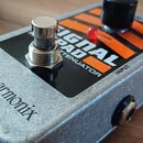 Kovový efekt pedál stříbrné barvy s nápisem electro-harmonix na horní hraně. Na horní ploše je černý štítek s bílým a oranžovým textem SIGNAL PAD ATT…