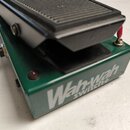 Zelený wah-wah pedál s černým stupněm. Na boku je bílý nápis Wah-wah switch+. Povrch pedálu vykazuje drobné oděrky a znečištění.