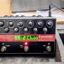 Černý efekt pedál s nápisy Eventide Harmonizer PITCHFACTOR. Zařízení má v horní části dvanáct otočných ovladačů s popisy jako Dry Mix, Wet Mix, Pitch…