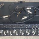 Na fotce jsou dvě černé rackové jednotky naskládané na sebe a několik audio kabelů. Horní zařízení má nápis TASCAM US-1641 16x4 96k/24-bit USB 2.0 Au…