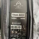 Zadní panel černého aktivního reproduktoru v ochranném textilním potahu. Na přístroji jsou nápisy Wharfedale Pro, WWW.WHARFEDALEPRO.COM a Titan-AX12.…