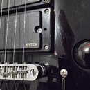 Detail černé elektrické kytary s dvěma snímači typu humbucker. Na obou snímačích je bílý nápis EMG. Je vidět stříbrný kobylník a přepínač tónů, povrc…