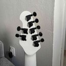 Fotografie zachycuje zadní stranu bílé hlavy elektrické kytary. Na hlavě jsou instalovány šest černých ladících mechanismů. Povrch nástroje je hladký…