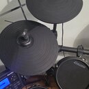 Elektronická bicí souprava s černými gumovými pady a činely. Na dvou viditelných bubnech je bílý nápis CARLSBRO. Modul ovládání obsahuje displej a ná…