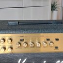 Kytarový kombozesilovač s černým texturovaným krytem a zlatým předním panelem. Na panelu je nápis JVM 205C a text 50W Valve Amplifier. Ovládací prvky…