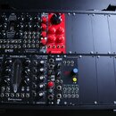 Fotografie zachycuje modulární syntetizátor v černém kufru. Na panelech jsou vidět nápisy enica fusion, BLACK MULTI-CV, BLACK QUAD VCA2, enica synths…