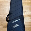 Černý polotvrdý obal na hudební nástroj s prošítým povrchem. Na přední části je bílý nápis mono® a níže logo Ernie Ball MUSIC MAN. Obal je vybaven ru…