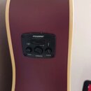 Detail na ovládací panel akustické kytary v tmavě fialové barvě s krémovým lemováním. Černý plastový panel nese bílý nápis FISHMAN® a tři otočné ovla…