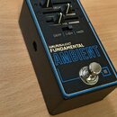 Černý efekt pedál s modrým rámečkem a nápisy WALRUSAUDIO, FUNDAMENTAL a AMBIENT. Na horní části jsou dva posuvníky s popisky DECAY a MIX, pod nimi js…