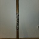 Na fotografii je zobrazen didgeridoo vyrobený z hnědého dřeva s válcovým tvarem. Střed nástroje je zdoben tmavě hnědým ornamentem s bílými tečkami a…
