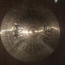Kruhový mosazný činel s výrazným koncentrickým žebrováním povrchu. Na levé straně je nápis „paiste“ a pod ním menší text „SWISS MADE“. Na pravé stran…