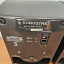 Zadní strana černého aktivního monitoru značky SONODYNE. Na zařízení je nápis SRP 202 active monitor, Designed and manufactured by Sonodyne, India a…