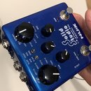 Modrý efekt pedál s kovovým povrchem a nápisy bílou barvou. Na horní straně je logo NUX, název modelu Studio Solid a označení I.R. & Power Amp Simula…