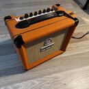 Kytarový kombozesilovač v oranžovém vinylu s béžovou textilní maskou. Na předním panelu je umístěno logo ORANGE a nad ním dekorativní emblem. Horní o…