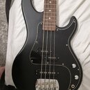 Černá elektrická basová kytara s matným povrchem a tmavě hnědým hmatníkem. Nástroj má černý pickguard a dva snímače. Na těle nejsou viditelná žádná l…