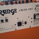 Zadní strana kytarového komba v oranžovém potahu. Na bílém zadním panelu je velký nápis ORANGE a modelové označení CRUSH 35RT. Panel obsahuje vstupy…