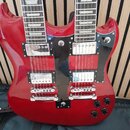 Červená elektrická kytara s dvěma hmaty (double neck). Nástroj má dva humbuckery na každém hmatu, chromované mosty a čtyři černé oválné ovládací knof…