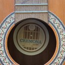 Detail rozetky akustické kytary s dřevěnou deskou a ozdobným lemováním. Uvnitř rozetky je nalepený štítek s nápisy „MADE IN CZECHOSLOVAKIA“, „CREMONA…