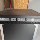 Černý výkonový zesilovač v rackovém provedení s nápisy D.A.S. ELECTRONIC SERIES a E-2 HIGH PERFORMANCE POWER AMPLIFIER. Přední panel obsahuje vypínač…