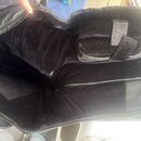 Otevřený černý polstrovaný obal z textilie s vnitřním výplní z černého plyšového materiálu. Uvnitř je vidět připevněný popruh se suchým zipem. Povrch…