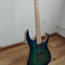 Elektrická kytara s trupem v modro-zeleném přechodovém odstínu a viditnou strukturou dřeva. Nástroj má světlý hmatník, dva humbuckery a dvě ovládací…